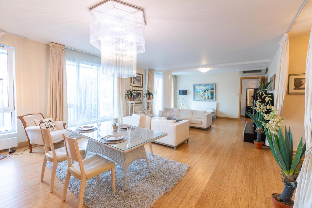リガにあるRoyal Penthouse Whith Free Parkingのテーブルと椅子のあるダイニングルームとリビングルーム