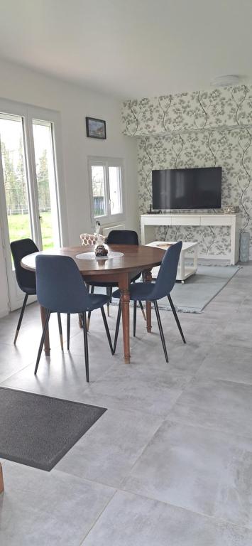 une salle à manger avec une table et des chaises en bois dans l'établissement Le refuge, à Lamballe Armor