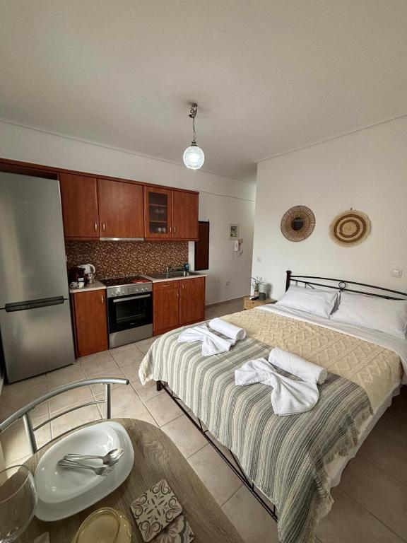 Un dormitorio con una cama grande y una cocina. en Little Diamond Stay, en Mytilini