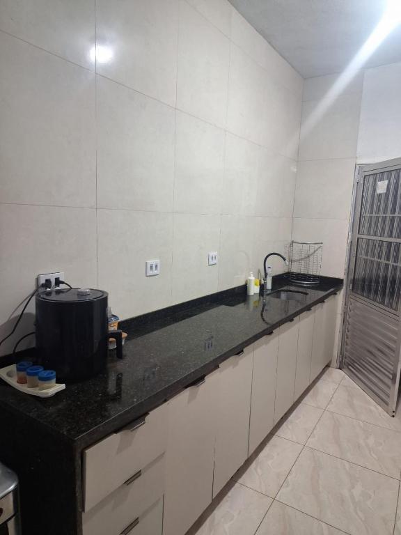 a kitchen with a black counter top and a sink at Doce Lar 58- Casa Evento in Cabo de Santo Agostinho