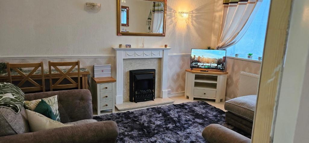 a living room with a fireplace and a television at Barton Beach First Floor Holiday Apartment Mablethorpe in Mablethorpe