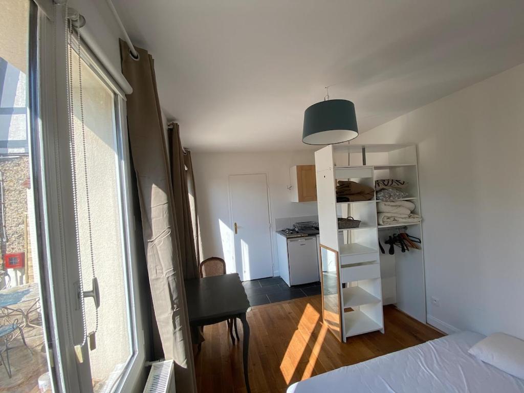 une chambre avec un lit et une pièce avec une fenêtre dans l'établissement Next castle park studio, à Saint-Cyr-lʼÉcole
