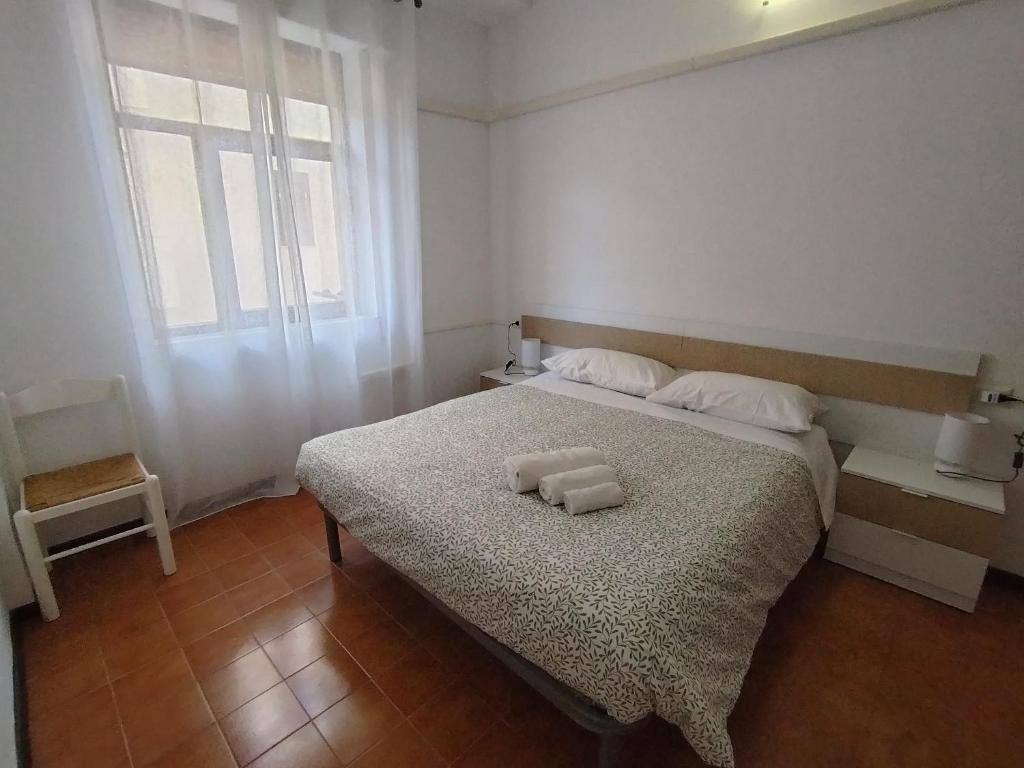 una camera da letto con un letto con due asciugamani sopra di A due passi dal mare ad Alghero