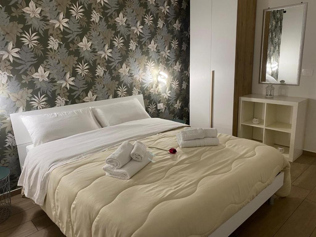 a bedroom with a large bed with towels on it at Il Tulipano house in Catania