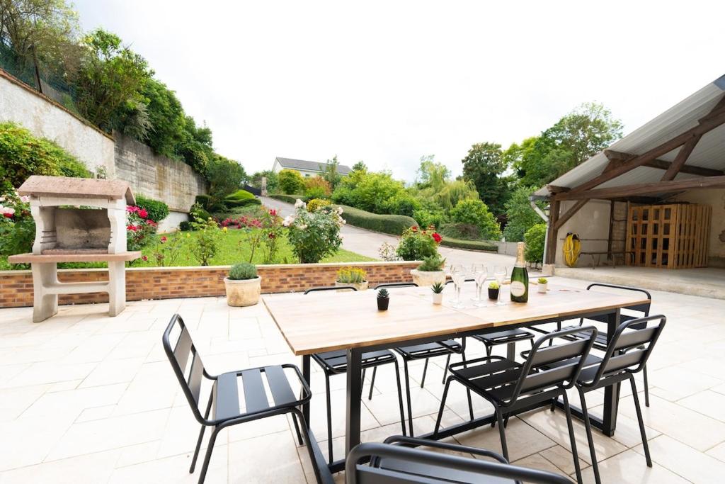 a wooden table and chairs on a patio at Évasion à Oiry Villa Madeline in Oiry