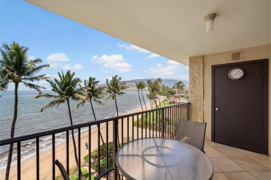 a balcony with a table and a view of the beach at Kihei Beach, #603^ condo in Kihei