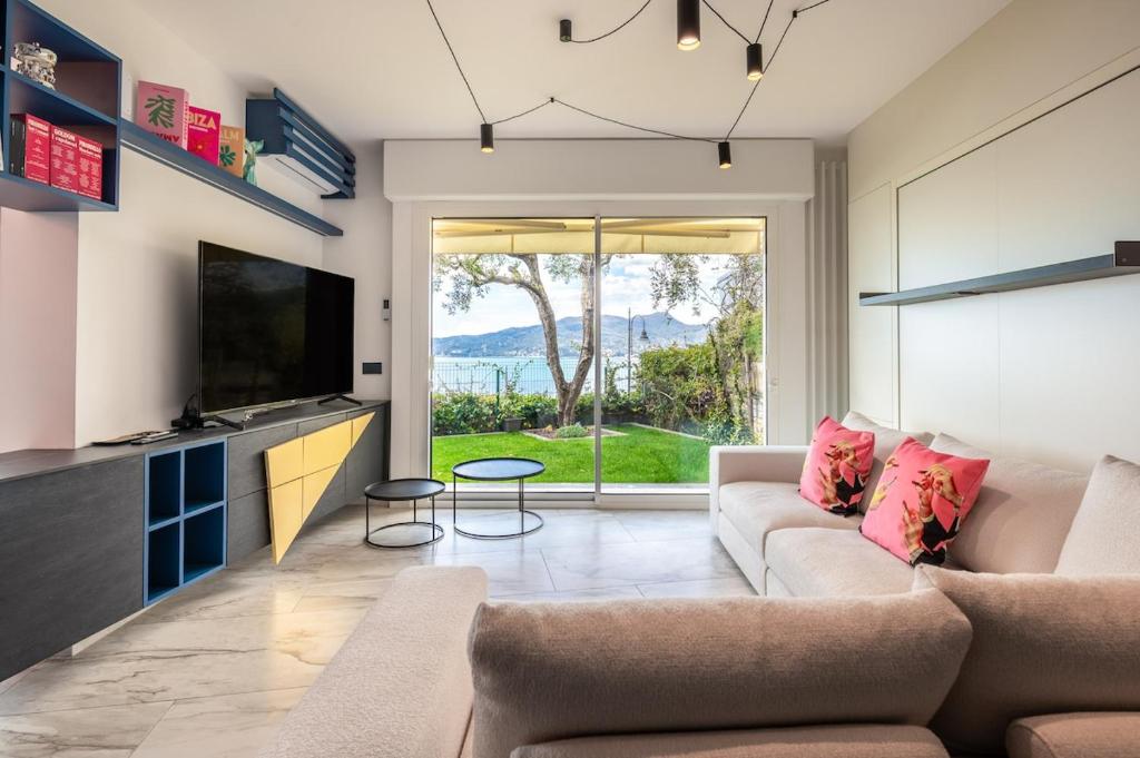 a living room with a couch and a tv at Valerie Luxury House And Spa in Zoagli