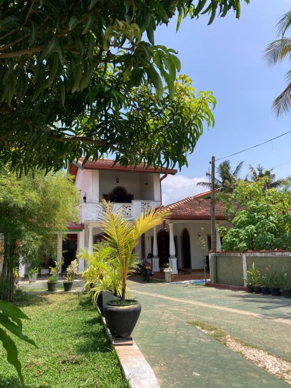 une maison avec un palmier devant dans l'établissement Costa's Villa, Tropical Oasis, Sigiriya Room, à Kepungoda