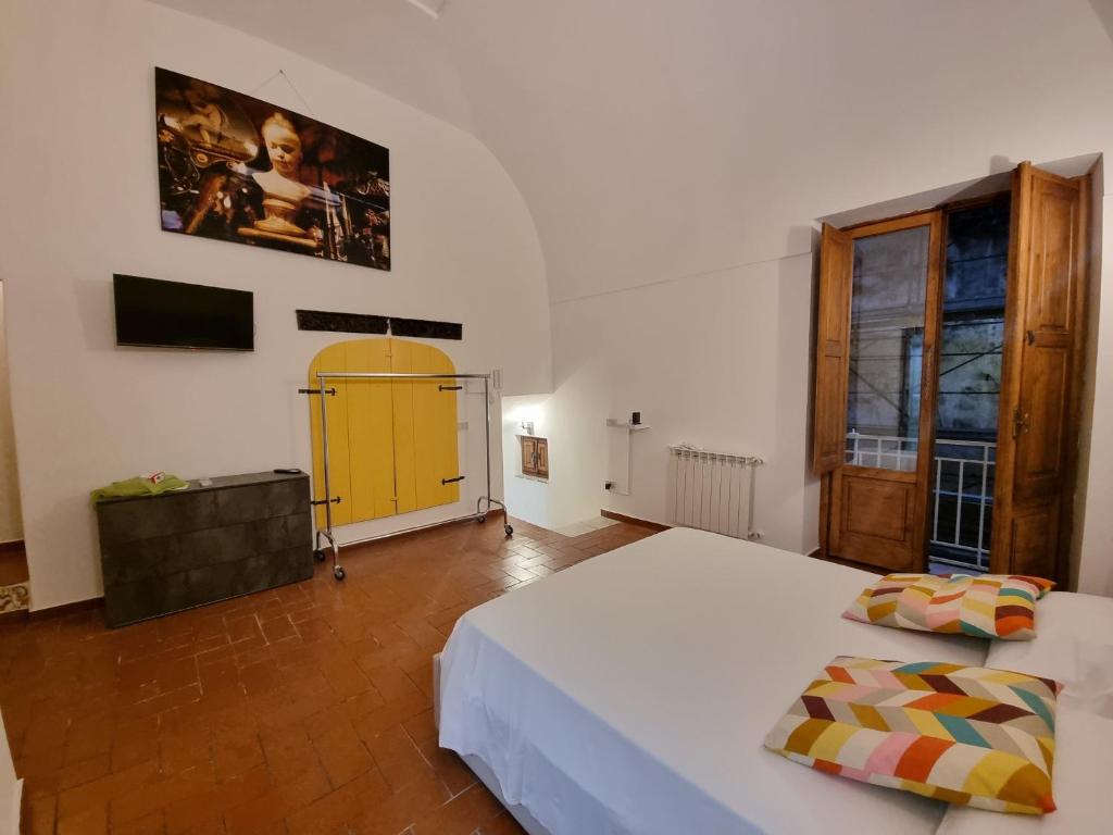 ein Schlafzimmer mit zwei Betten und einer gelben Tür in der Unterkunft Guest house degli scalzi in Gaeta