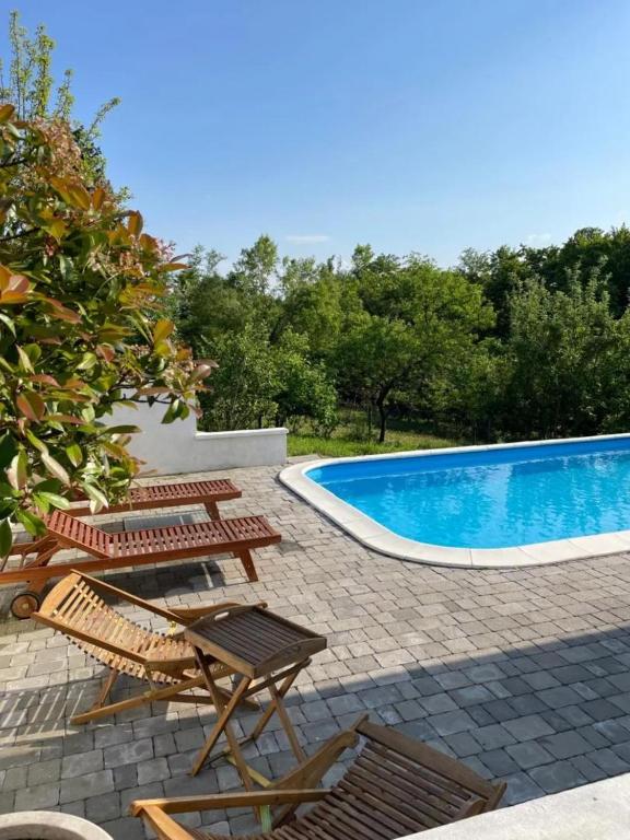 eine Terrasse mit Stühlen und ein Swimmingpool in der Unterkunft Tiny house palma in Šiljakovina