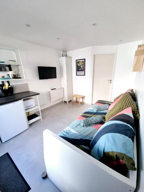 une chambre blanche avec un lit et un bureau dans l'établissement Coeur de Bourg La Garnache Studio, à La Garnache