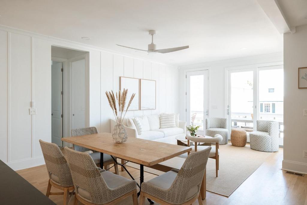 Una sala de estar con una mesa y sillas de madera. en Allure by Mira-Mar, en Wrightsville Beach