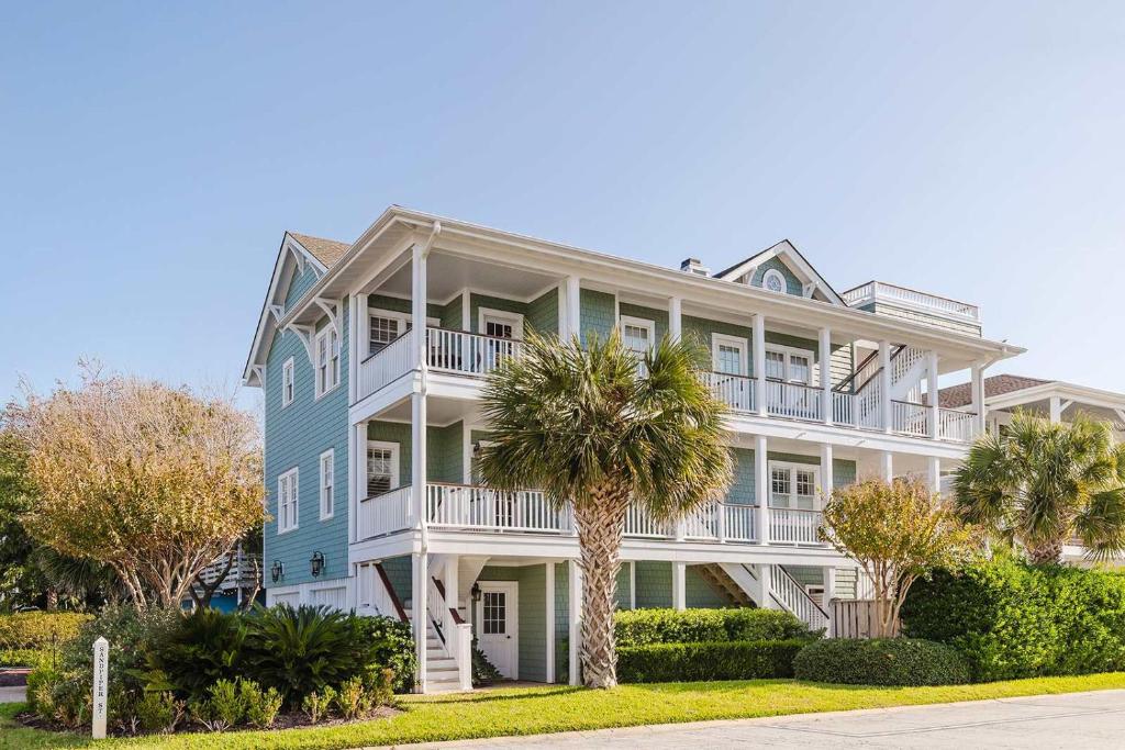 een groot huis met een palmboom ervoor bij 1500 Lumina in Wrightsville Beach