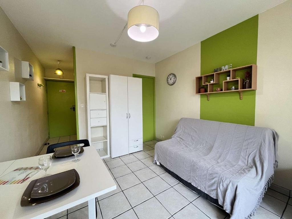 - une chambre avec des murs verts, un lit et un bureau dans l'établissement STUDIO La Rochelle - LR930-001, à La Rochelle