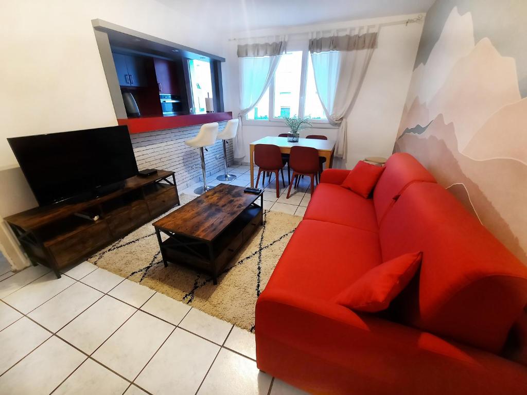un salon avec un canapé rouge et une table dans l'établissement Évasion - Appartement 6 Prs, 2 Ch, avec Balcon, à Dijon