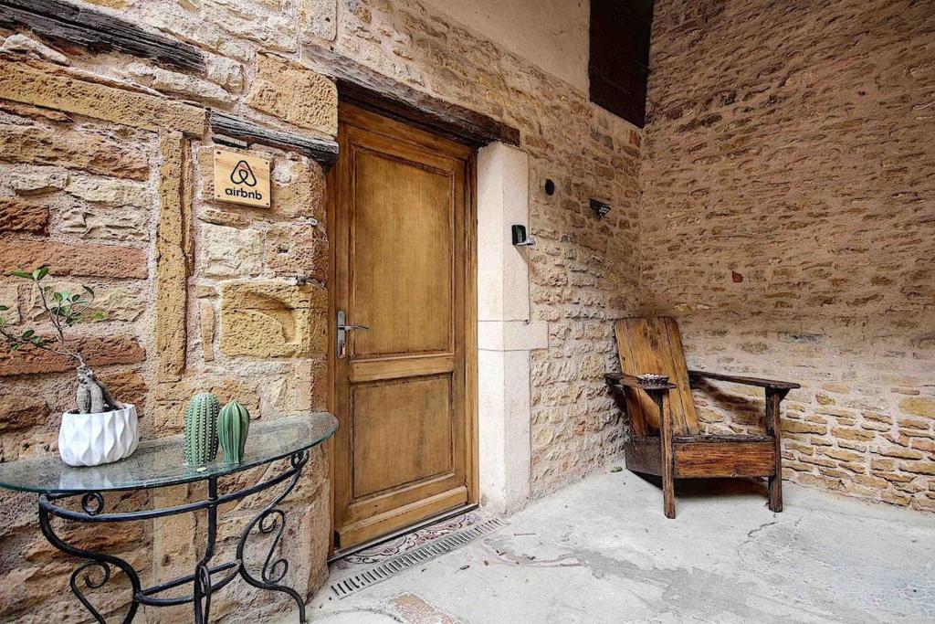 a room with a wooden door and a table and a chair at La Casa Dorée in Charnay