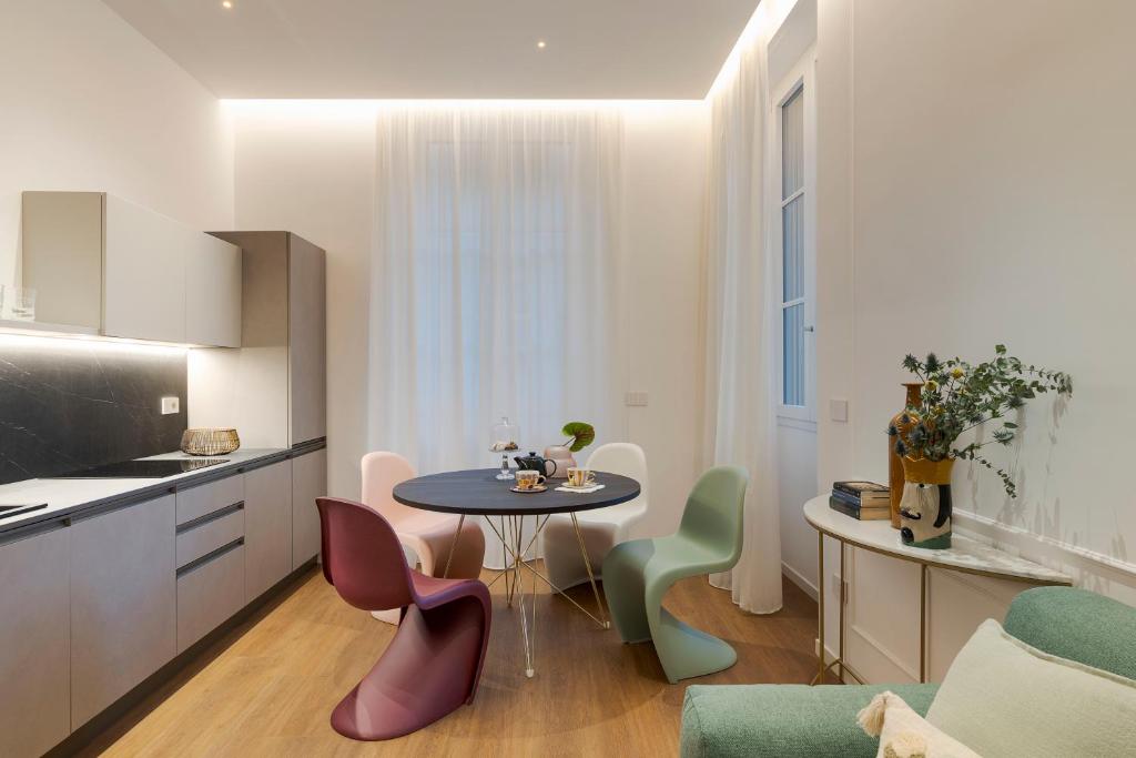 una cucina con tavolo e sedie in una stanza di Elysium Boutique Apartments - Catania a Catania