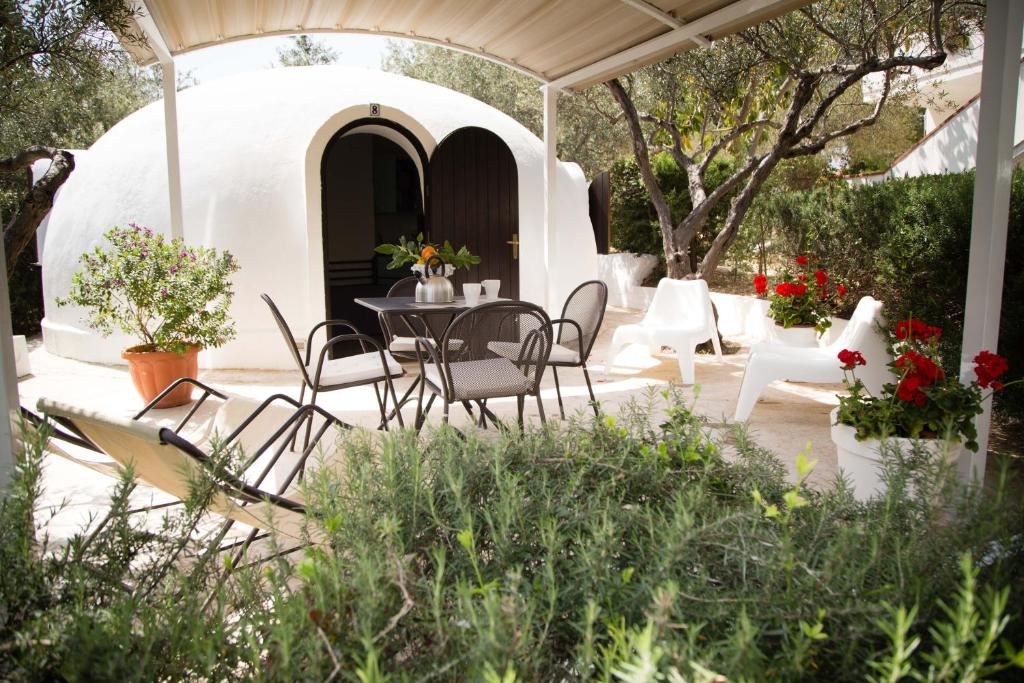 eine Terrasse mit einem Tisch und Stühlen unter einem Pavillon in der Unterkunft Residence Guidaloca in Scopello