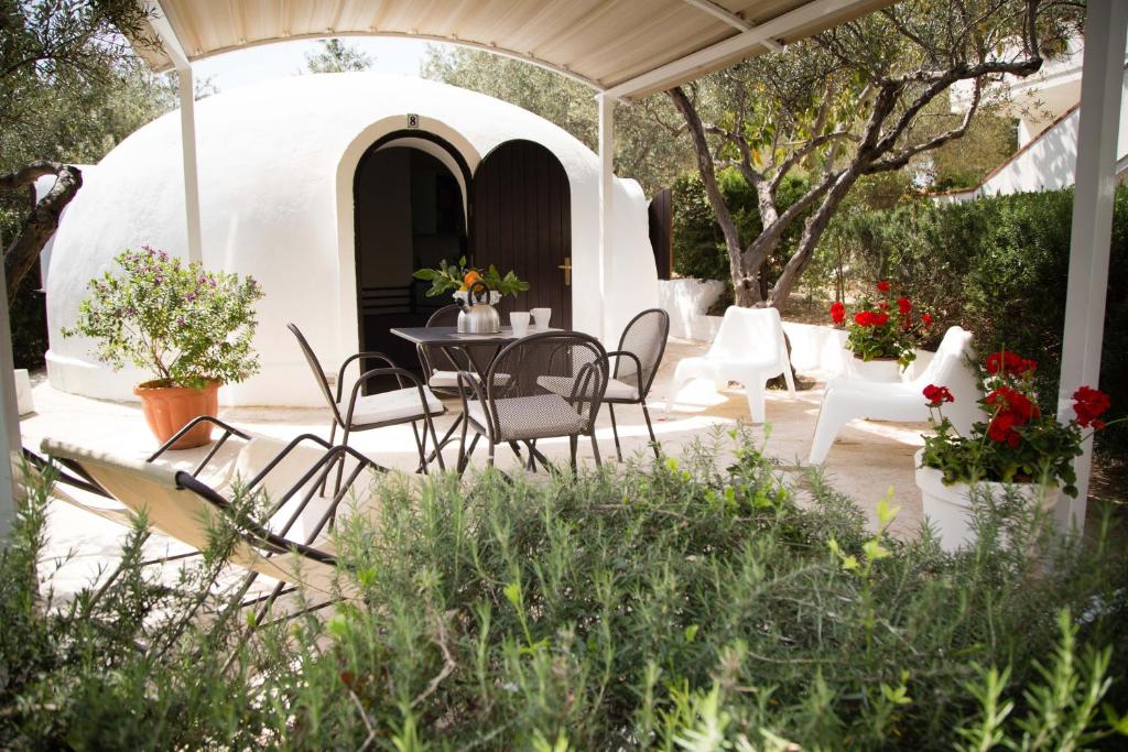 a patio with a table and chairs under a gazebo at Residence Guidaloca in Scopello
