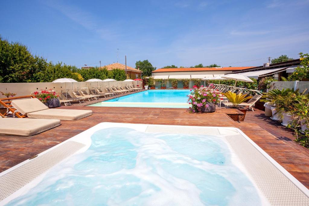 a large swimming pool with chairs and a swimming pool at La Mimosa Camping in Fano