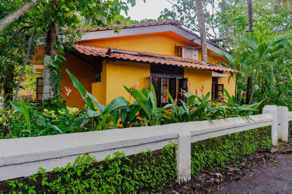ヴァガトールにあるGOAROUND- Grand Chivar 1BHK Villa by Goaround Homes at Vagatorの前に柵がある黄色い家