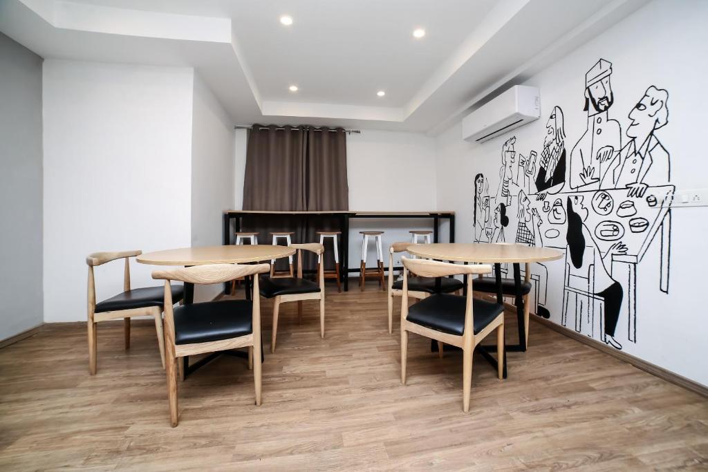 a dining room with tables and chairs and a mural at OYO 91997 Edhotel Smk Models Syariah in Pasanggaran