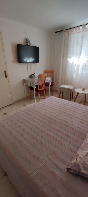 a room with a large bed with a tv on the wall at Guesthouse Palma in Mali Lošinj