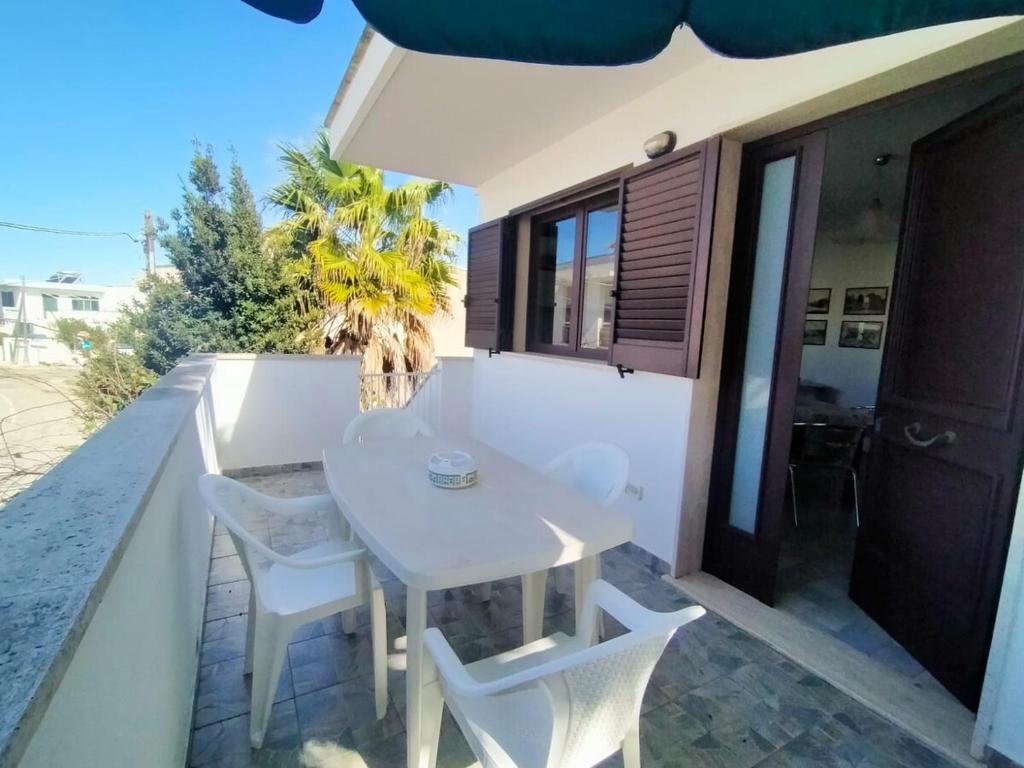 a white table and chairs on the balcony of a house at La Casa del Marinaio P1 in San Foca