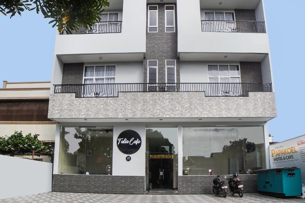 two motorcycles parked in front of a building at SUPER OYO Capital O 92066 Papakoel Hotel & Cafe in Medan