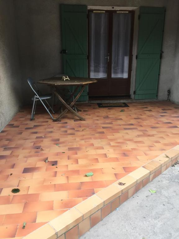 Cette chambre dispose de parquet, d'une table et de portes vertes. dans l'établissement Quadrale, à Sotta