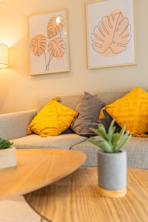 - un salon avec un canapé, des oreillers et une table dans l'établissement Duplex Confortable en Centre avec 2 Chambres, à Châlons-en-Champagne