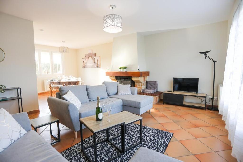 a living room with a couch and a table at La villa Fontaine in Moussy