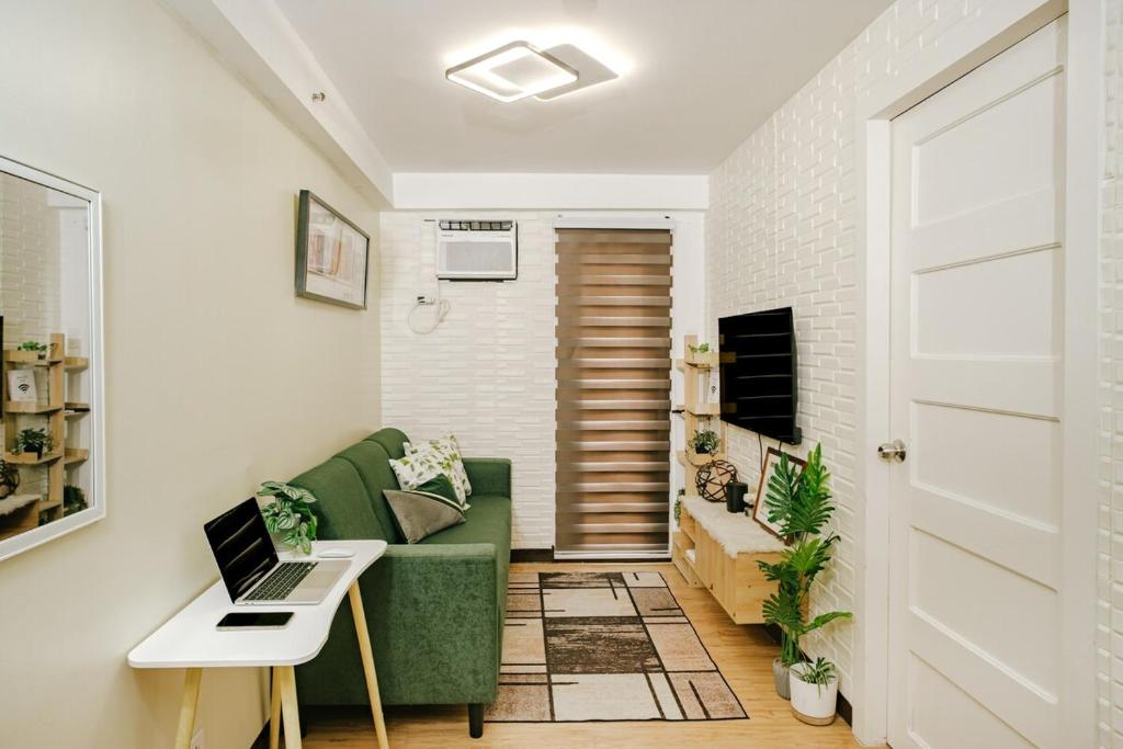 a living room with a green couch and a table at AR09 HBRentals 1BR Smart Unit in Davao City