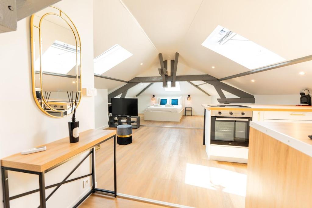 a kitchen and living room with a vaulted ceiling at Nid douillet sous les combles in Châlons-en-Champagne
