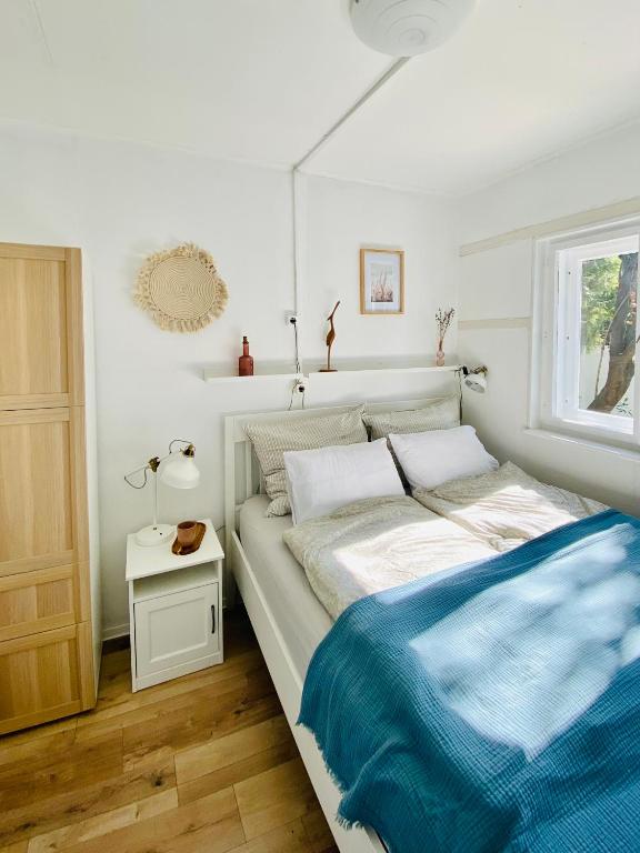 a bedroom with a bed with a blue blanket at Bánhiday M4 Weekendhouse in Balatonakarattya