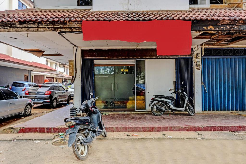 une moto garée sur le trottoir devant un magasin dans l'établissement Hotel O Jodoh Stay SyariahNearPelabuhan Feri Harbor Bay, à Nagoya