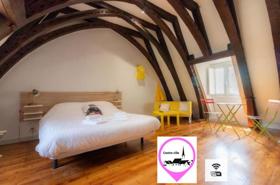 a bedroom with a bed in a room with wooden floors at Les Chambres du "Coup de Coeur de Sarlat" in Sarlat-la-Canéda