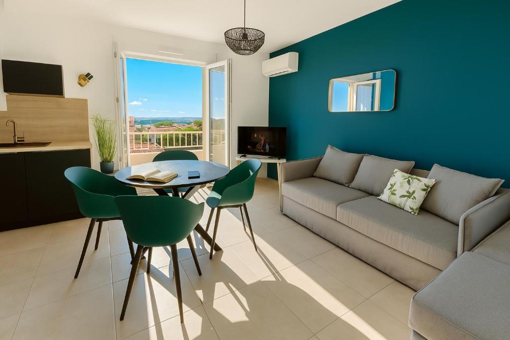 Una sala de estar con un sofá, una mesa y sillas. en "ZEN" 100m de la plage avec parking, vue mer et vue montagne, en Canet-en-Roussillon