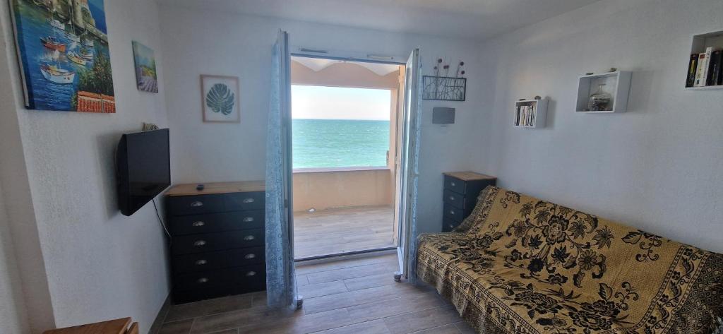 - un salon avec un canapé et une porte donnant sur l'océan dans l'établissement Comme sur un bateau, à Collioure