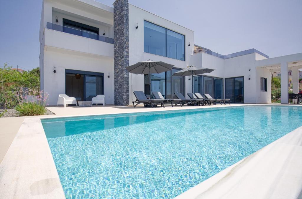 a swimming pool in front of a villa at Luxury Villa Apeiro in Plaka in Plaka