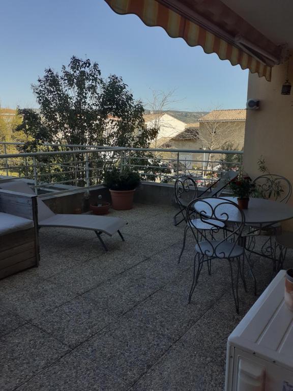 un patio avec tables et chaises sur un balcon dans l'établissement Bichette, à Cavaillon