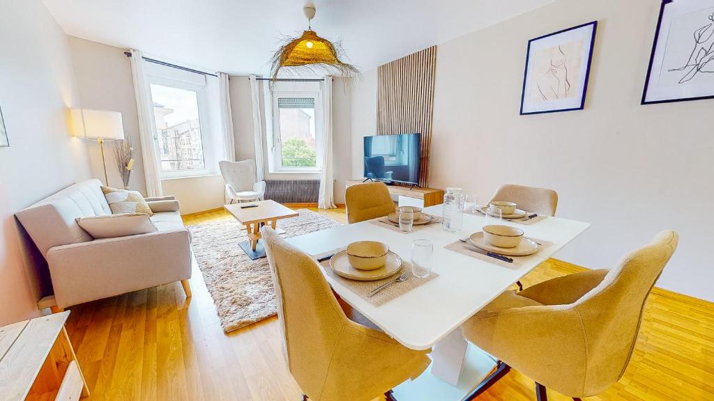 un salon avec une table et des chaises blanches dans l'établissement L'Écrin Cozy - Nancy Thermal - cité judiciaire 4 personnes, à Nancy