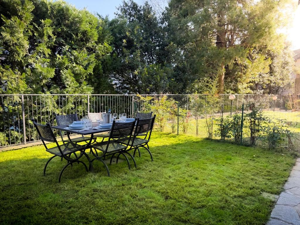 a table and chairs sitting on the grass at Dimora Larianda - Private Parking and Garden in Laglio