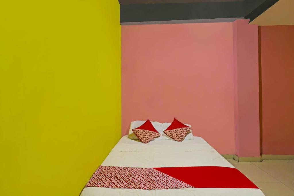 une chambre avec des murs colorés et un lit avec deux oreillers dans l'établissement Hotel O Pelangi House 789 Syariah, à Nagoya