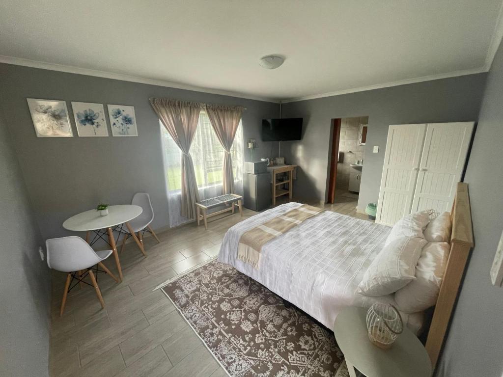 a bedroom with a bed and a table and chairs at York-R102 Airport Road - Modern Comfort in George