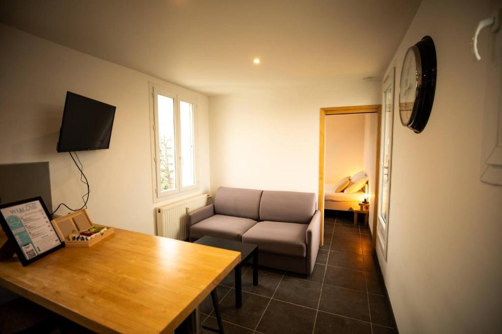 una sala de estar con un sofá y una mesa en Le Panorama Valentinois, en Valence