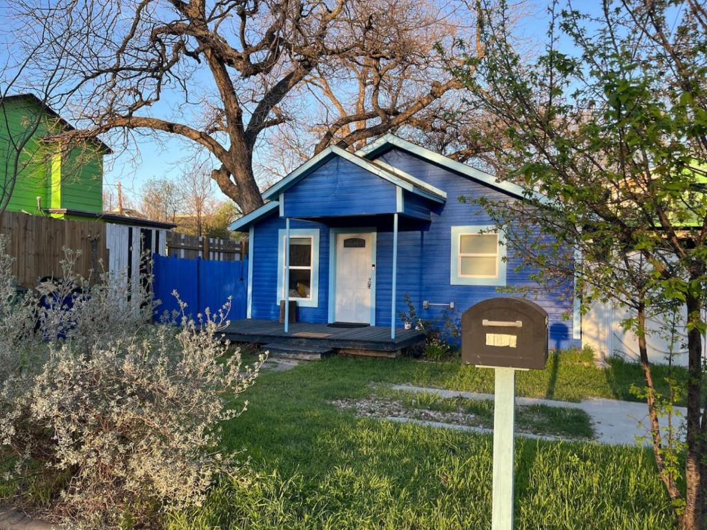 a blue house with a sign in front of it at East Side Blue Bonnet Cottage in Austin