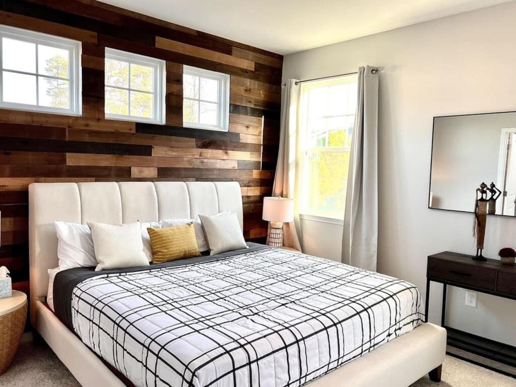 a bedroom with a bed and a wooden wall at The Villas Buckingham 10 mins to RDU Airport Duke Downtown in Durham