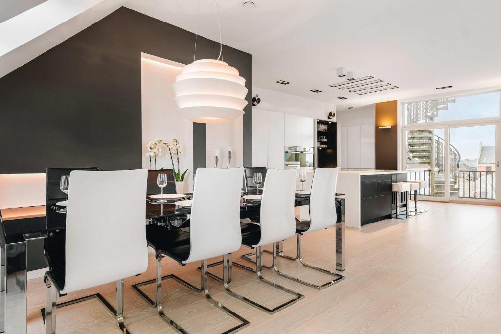 a dining room with a table and white chairs at DINBNB Apartments l Luxury Penthouse l Roof Terrace l Central Bergen in Bergen