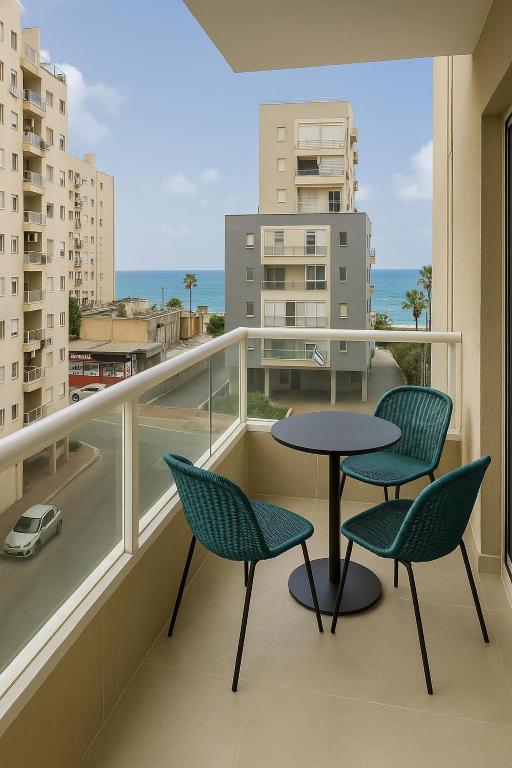 a balcony with a table and chairs and a view of a city at Sweet apartment in Netanya